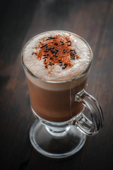 Delicious hot chocolate with cinnamon on the brown wood table