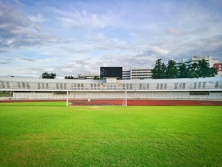 Fototapeta na wymiar green grass lawn stadium with blue sky background