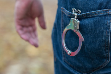 Metal handcuffs in a back jeans pocket
