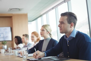 Concentrated business people sitting at conference table during