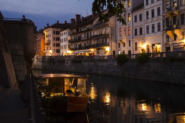 Fototapeta na wymiar Romantic evening on Ljubljanica river under Ljubljana castle (Slovenia)