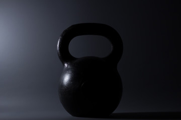 Fototapeta na wymiar iron kettlebell weight on a dark background. Sports Equipment.