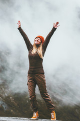 Happy woman in foggy mountains Travel Lifestyle success motivation concept adventure active vacations outdoor blessing emotions raised hands