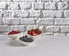 strawberry raspberry blueberry behind brick wall