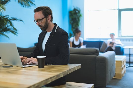 Male executive using laptop at desk