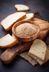 Bowl of breadcrumbs and slices of a loaf