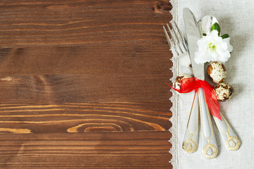 Cutlery and linen napkin on a wooden table. Decorative Easter arrangement. Selective focus.