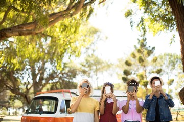 Friends holding smart phone in front of face