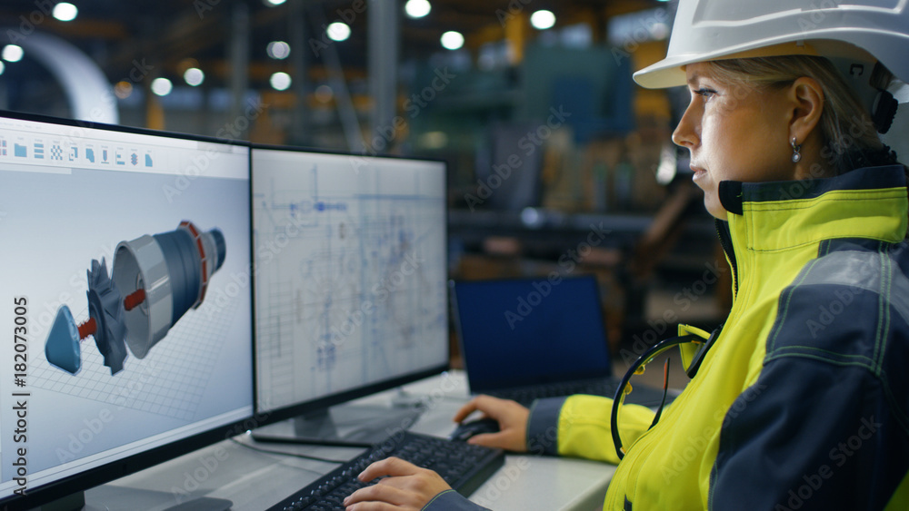 Poster inside the heavy industry factory female industrial engineer works on the personal computer on the t