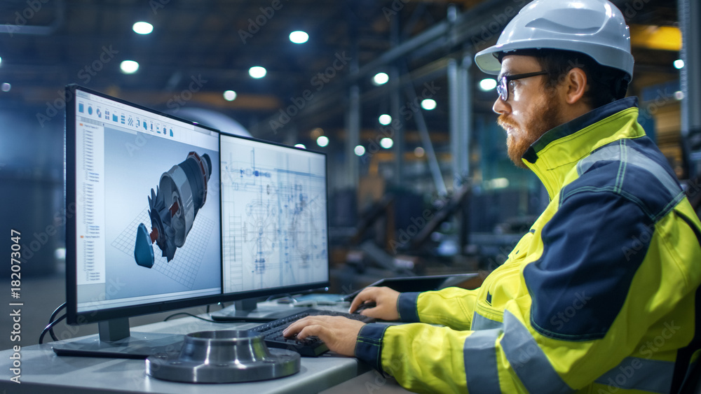 Poster inside the heavy industry factory industrial engineer works on the personal computer designing turbi