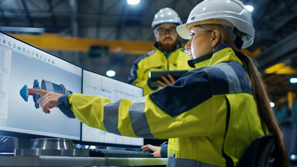 Inside the Heavy Industry Factory Female Industrial Engineer Works on Personal Computer She Designs...