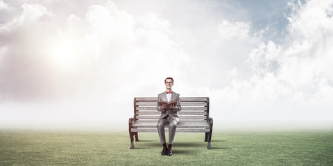 Young businessman or student studying the science in summer park