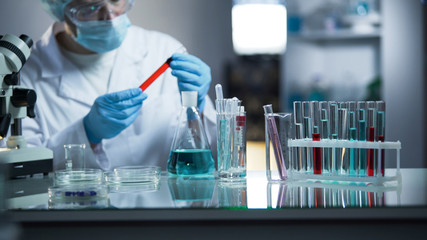 Laboratory assistant examining medical blood sample, looking for sediments