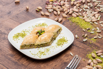baklava in the white plate wooden background