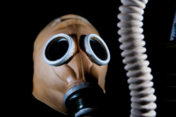 Old , vintage, european military gas mask isolated on black background, focus on the main filter.