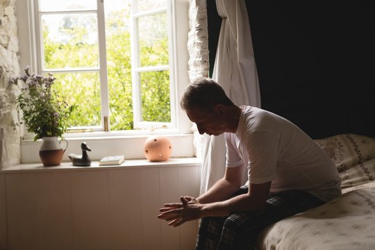 Senior man relaxing in bedroom at home
