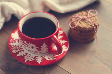 Red Christmas mug with coffee and cookies on the wooden table