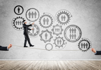 Business concept of risk support and assistance with man balancing on rope