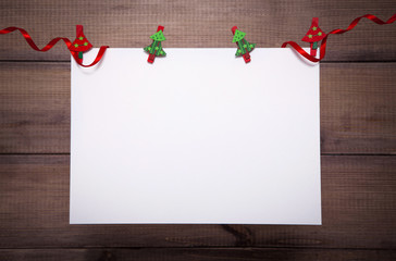 Christmas background with copy space. White sheet hangs on clothespins with decorative elements over wooden backdrop.