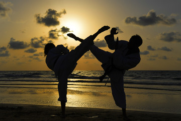 Karate fighters at sunset on the beach © PROMA