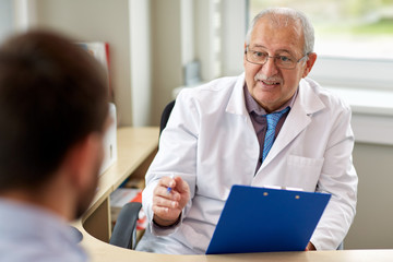 Fototapeta premium senior doctor talking to male patient at hospital