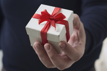     A man holding a gift box in his hands 