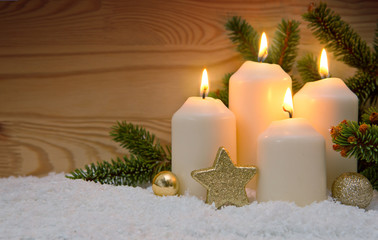 Christmas decoration and four burning Advent candles.