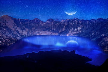 Lake in the crater of a volcano against the background of the starry sky. Reflection of the moonlight on the water. Indonesia. Rinjani volcano. © delbars