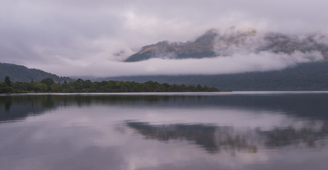 Fototapeta premium Scotland, UK Loch Lomond Mountains in mist with clouds 