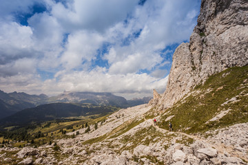 Two trekkers along path with beautiful dolomitic landscape, Valparola Pass, Dolomites, Italy