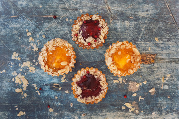 Assorted mini tarts on rustic surface. Top view, blank space