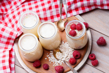 Jars with yogurt, raspberries and oat flakes 