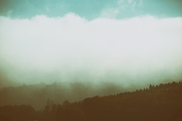 Nebel in den Bergen  / Wolken und Nebelbänder ziehen über die bewaldeten Bergrücken einer Bergkette.