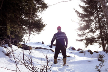 Mann mit Norweger Pulli im Schnee