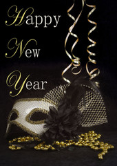 New Year's Eve themed image of gold and silver carnival mask decorated with black flower and...