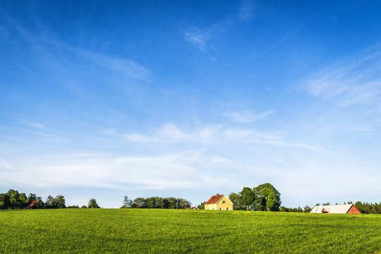 Yellow farmhouse on a rural green field