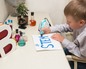Teenager boy draws different things by 3d pen with a blue plastic handle. Mathematics. Engineering....
