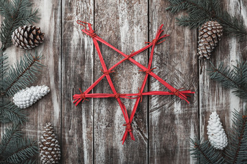 Old wooden background. Fir branches, cones. Christmas Fellowship, New Year and Xmas. The red decorative star in the center. Holiday card. Xmas and Happy New Year composition. Flat lay, top view