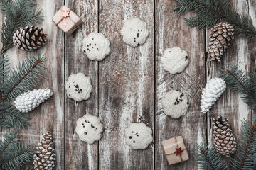 Old wooden background. Fir branches, cones. A circle of sweet biscuits. Space for a holiday message. Gifts. Holiday card. Xmas and Happy New Year composition. Flat lay, top view