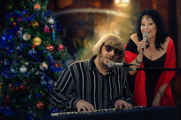 Christmas Concert Captivates Partygoers: Musical Duo Enchants Audience with Festive Performance by Ornament-Laden Tree.