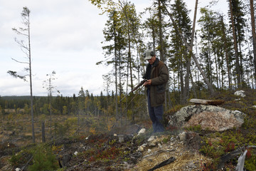 Obraz premium Moose hunter with a little fire using his smartphone