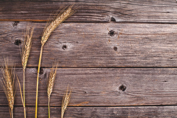 Ears of rye on the rustic wooden background, flat lay