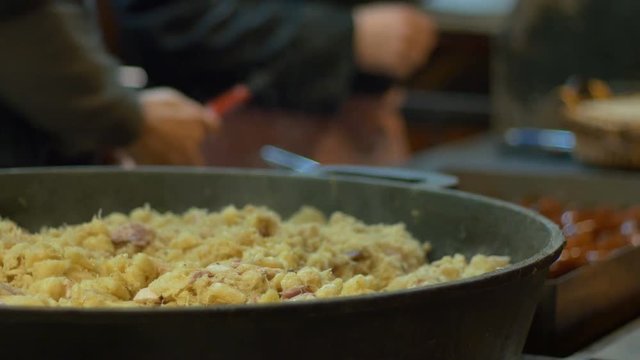 Street cook is preparing Czech food in mobile kitchen.