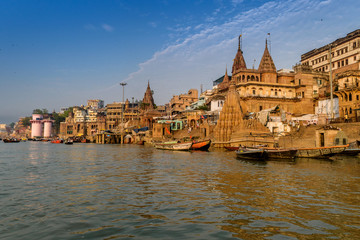 A view from River Ganges of Old Historical Varanasi city with weathered buildings at the time of Sunrise