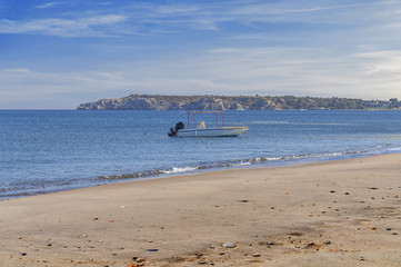 Fototapeta na wymiar Small boat docked on sea beach with sky background