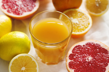 Citrus juice and fruit grapeprut, lemon and orange on a light background.
