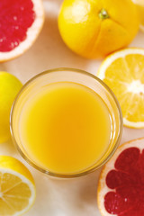 Citrus juice and fruit grapeprut, lemon and orange on a light background.