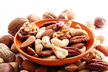 bowl with mixed nuts on white background. Healthy food and snack. Walnut, pecan, almonds, hazelnuts...