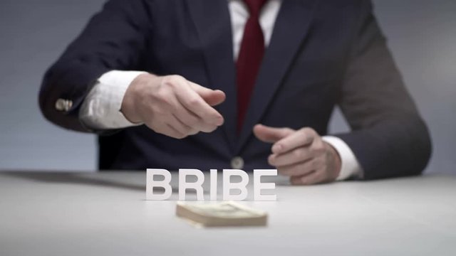 Businessman throwing pack of money on table. Illegal bribe to oligarch