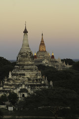 Two White Pagodas Stand Out in Sunset Among Fields of Bright Green Foliage adn Trees. Taken at...